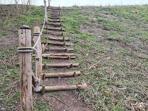 A wooden staircase with a rope handrail, leading up a grassy hill. - Beautiful Holiday Home in Borre (Borre)