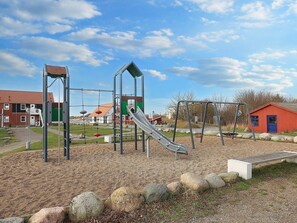A playground with a slide, swings, and climbing structures.