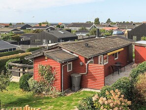 A red building with a small patio, surrounded by other houses. - 5 Person Holiday Home in Karrebaeksminde (Karrebæksminde)