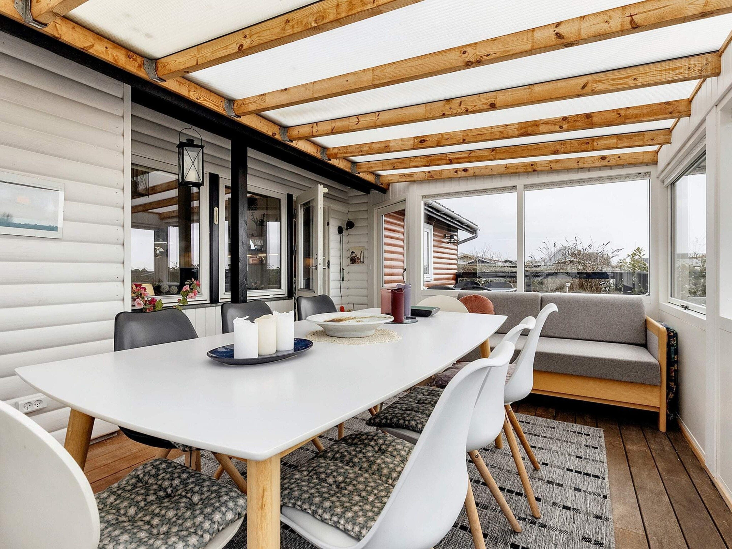 A dining area with a white table, chairs, and a bench.