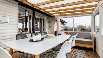 A dining area with a white table, chairs, and a bench.