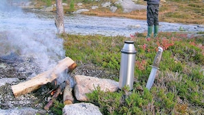 A person fishing by a river with a campfire nearby. - 7 Person Holiday Home in Melfjordbotn-by Traum (Rodoy)