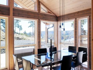A modern wooden interior with large windows, a glass table, and black chairs. - 10 Person Holiday Home in Sondeled-by Traum (Risør)