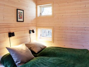 A cozy wooden cabin room with a bed, two windows, and a framed picture on the wall. - 10 Person Holiday Home in Sondeled-by Traum (Risør)