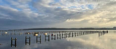 A calm lake with wooden docks extending into the water, surrounded by a rocky shoreline.