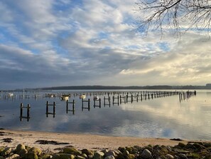 A calm lake with wooden docks extending into the water, surrounded by a rocky shoreline. - 6 Person Holiday Home in Haderslev (Haderslev)