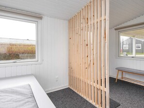 A room with a bed, a window, a wooden partition, and a bench. - 6 Person Holiday Home in Haderslev (Haderslev)
