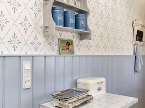 A kitchen with a white countertop, a vintage Brod toaster, and blue storage containers on a shelf. - 4 Person Holiday Home in Nysted (Nysted)