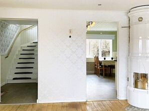 A staircase leading to a landing, a dining area with a table and chairs, and a white cylindrical object. - 8 Person Holiday Home in Anneby (Aneby)