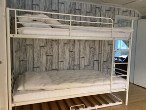 A bunk bed with a wooden wall and a window. - 8 Person Holiday Home in Anneby (Aneby)