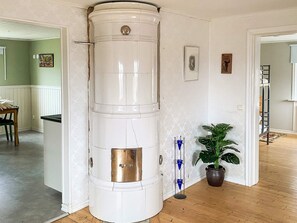A corner with a white cylindrical object, a potted plant, and a door leading to another room. - 8 Person Holiday Home in Anneby (Aneby)