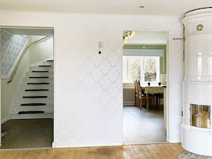 A staircase leading to a room with a radiator, a dining area with a table and chairs, and a white cylindrical object. - 8 Person Holiday Home in Anneby (Aneby)