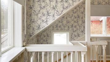 A staircase with white balusters and a patterned wallpaper.