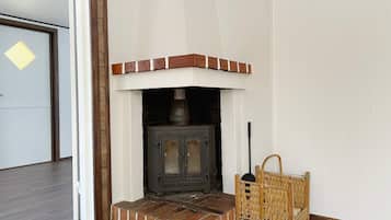 A room with a fireplace, a wicker basket, and a door.