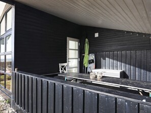 A covered outdoor seating area with a table and chairs, a door, and a window. - 4 Star Holiday Home in Karrebaeksminde (Karrebæksminde)