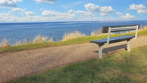 A bench overlooking a body of water with a clear sky. - 4 Person Holiday Home in Bogense (Bogense)