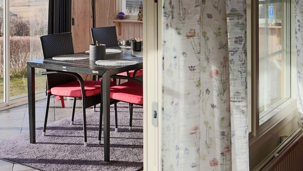 A dining area with a table and chairs, a floor lamp, and a view of the outdoors. - 4 Star Holiday Home in Varberg-by Traum (Varberg)