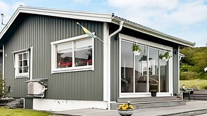 A modern house with a grey exterior, large windows, and a covered porch with a stone border. - 4 Star Holiday Home in Varberg-by Traum (Varberg)