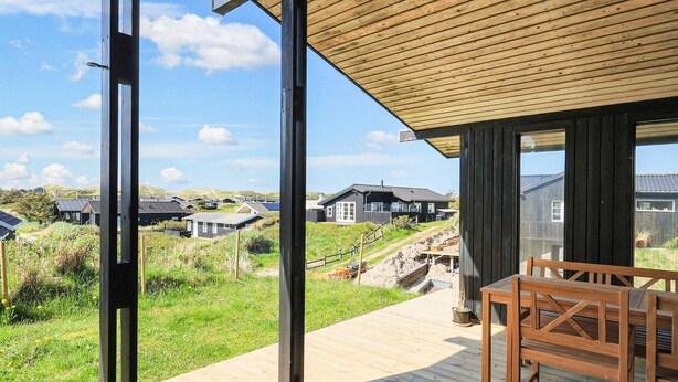 Eine Holzterrasse mit Blick auf Häuser im Hintergrund.
