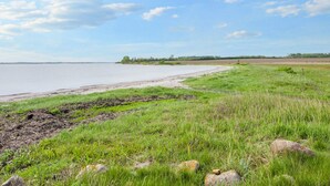 A grassy area with a body of water and a distant tree line. - 4 Person Holiday Home in Nordborg (Nordborg)