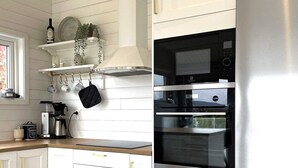 A kitchen with white cabinetry, a stainless steel refrigerator, and a coffee maker. - 4 Star Holiday Home in Uddevalla (Uddevalla)