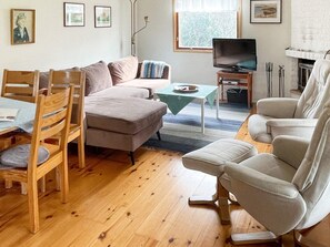A living room with a sofa, chairs, a television, and a fireplace. - 4 Star Holiday Home in Arild-by Traum (Arild)