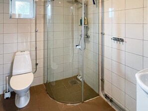 A bathroom with a toilet, a glass-enclosed shower stall, and a sink. - 4 Star Holiday Home in Arild-by Traum (Arild)