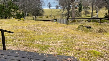 Una terraza de madera con vista a un lago y árboles.