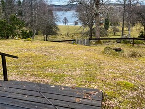 Une terrasse en bois offrant une vue sur un lac et des arbres.