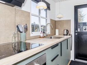 Een moderne keuken met een groot raam, een spoelbak en een deur.