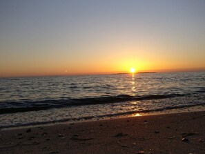 Ein Strand bei Sonnenuntergang über dem Wasser.
