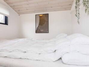 A bedroom with a bed, a map on the wall, and a window. - 4 Star Holiday Home in Logstor (Logstor)