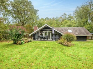 A modern house with a patio, a covered outdoor seating area, and a well-maintained lawn. - 5 Person Holiday Home in Toftlund (Toftlund)