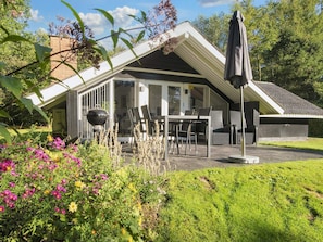 A covered outdoor seating area with a table and chairs, a grill, and an umbrella. - 5 Person Holiday Home in Toftlund (Toftlund)
