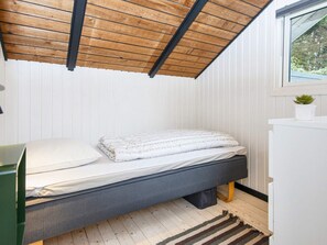 A compact bedroom with a single bed, a small desk, and a window with a view of greenery. - 5 Person Holiday Home in Toftlund (Toftlund)