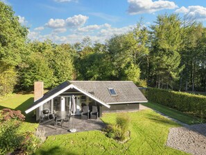 A modern house with a sloped roof, a patio with outdoor furniture, and a well-maintained garden. - 5 Person Holiday Home in Toftlund (Toftlund)