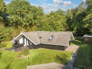 Una casa a un piano con tetto spiovente, un piccolo portico e un’area patio.