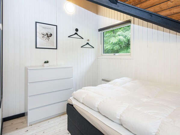 A bedroom with a bed, a dresser, a framed picture, a window, and a hanging light fixture. - 5 Person Holiday Home in Toftlund (Toftlund)