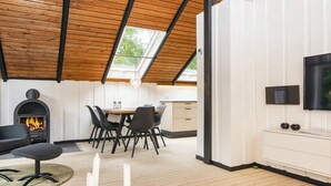 A modern interior with a fireplace, dining area, and a TV mounted on the wall. - 5 Person Holiday Home in Toftlund (Toftlund)