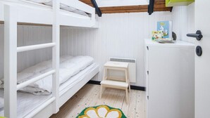 A bunk bed room with a skylight, a small wooden stool, and a white cabinet with a green accent. - 5 Person Holiday Home in Toftlund (Toftlund)