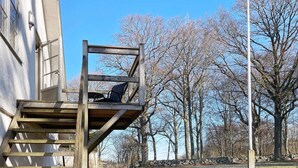 A wooden outdoor staircase leading to a deck with a chair. - 4 Star Holiday Home in Solvesborg-by Traum (Sölvesborg)