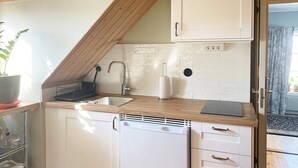A kitchen with white cabinets, a wooden countertop, a dishwasher, and a sink with a faucet. - 4 Star Holiday Home in Solvesborg-by Traum (Sölvesborg)