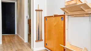 A room with a wooden door, a wall-mounted rack with tools, and a wooden shelf unit. - 5 Star Holiday Home in Oster Assels (Øster Assels)