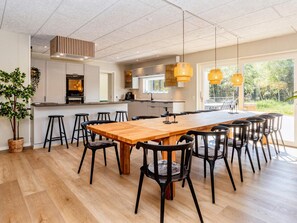 A modern kitchen with a large island, bar stools, and pendant lighting. - 5 Star Holiday Home in Oster Assels (Øster Assels)