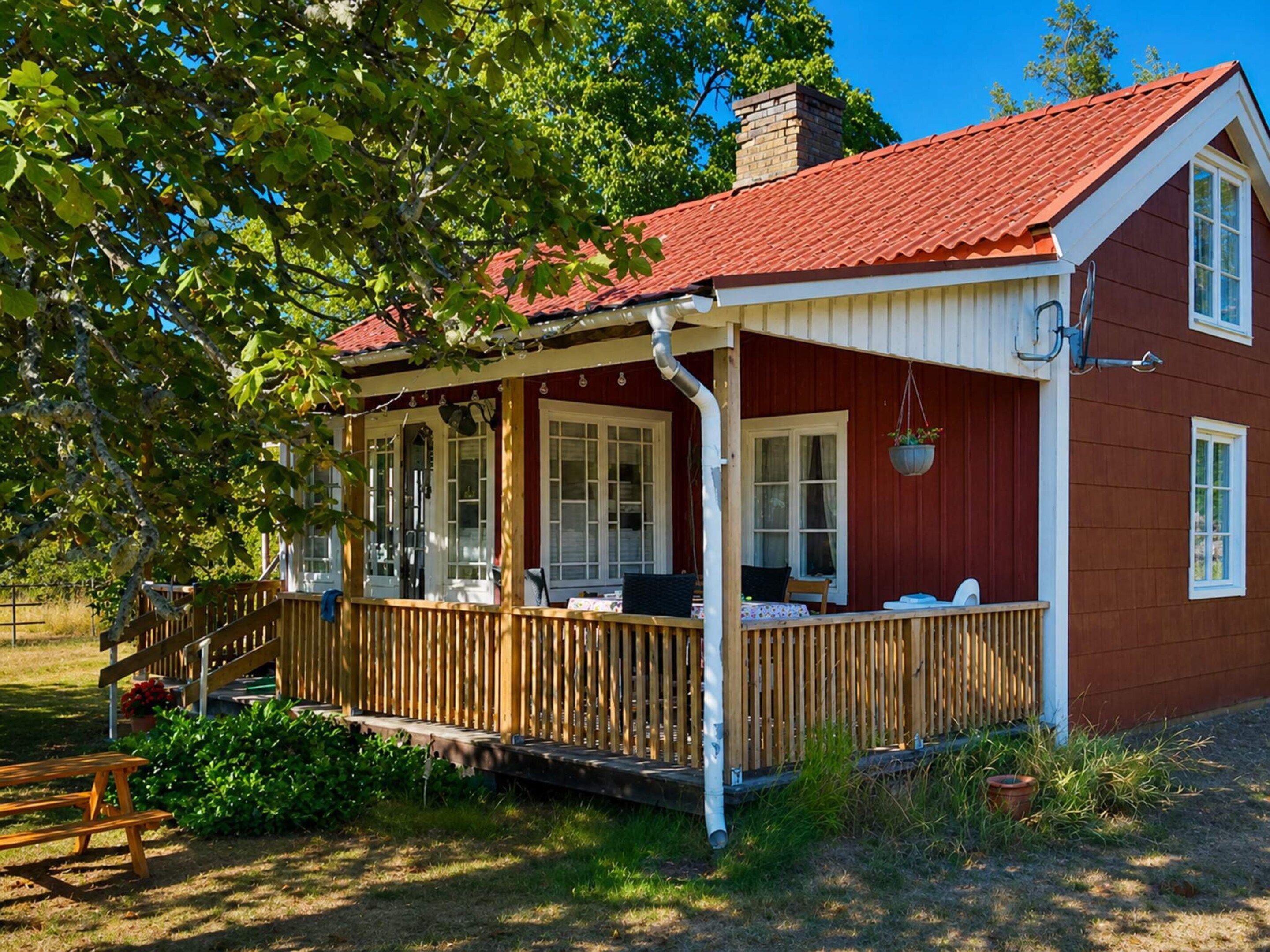 Una casa de fusta amb teulada vermella, un porxo i una xemenea.