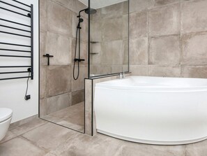 A modern bathroom with a freestanding bathtub, a glass-enclosed shower, and a towel rack. - 5 Star Holiday Home in Ansager (Ansager)