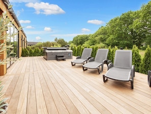 A wooden deck with outdoor seating and a hot tub. - 5 Star Holiday Home in Ansager (Ansager)