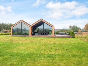A modern two-story house with large glass windows and a wooden exterior. - 5 Star Holiday Home in Ansager (Ansager)