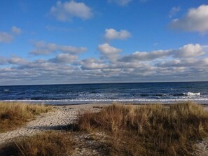 A beach with a clear sky and waves. - 4 Star Holiday Home in Vaeggerlose (Vaeggerlose)