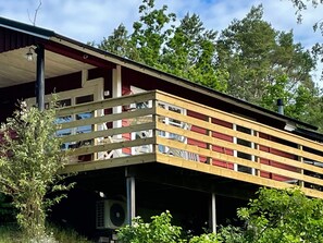 A two-story building with a balcony, an air conditioning unit, and a red roof. - 4 Person Holiday Home in Nynashamn (Nynashamn)
